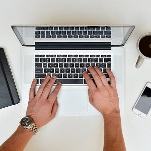 Hands placed over the keyboard on a laptop