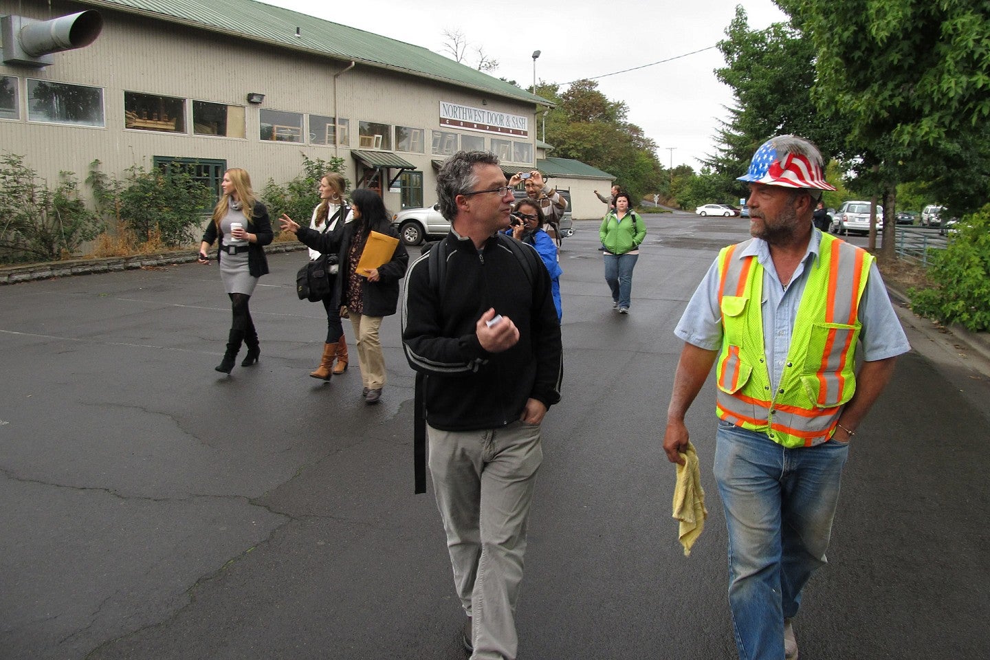 Faculty walks alongside worker with helmet on.