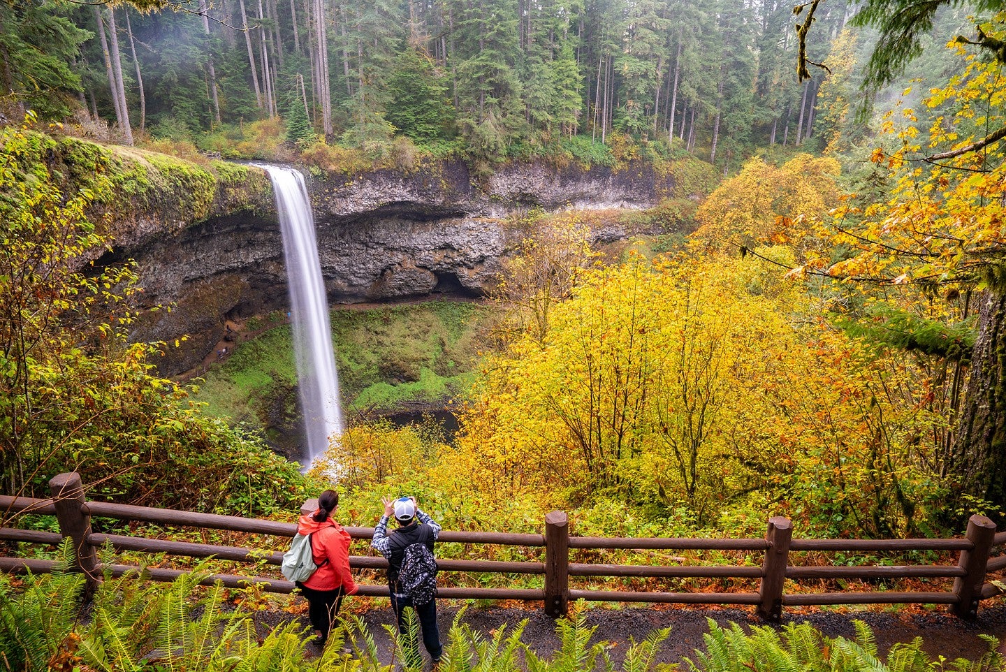 Two people taking photos of South Falls at Silver Falls State Park near Silverton Oregon