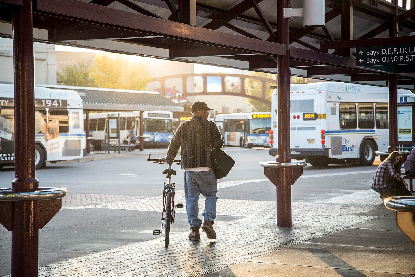 Man walks through an LTD bus station with his bike