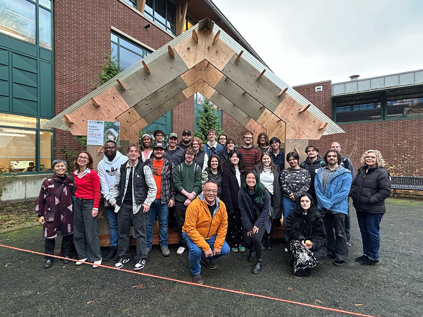 Students pose in front of wooden structure