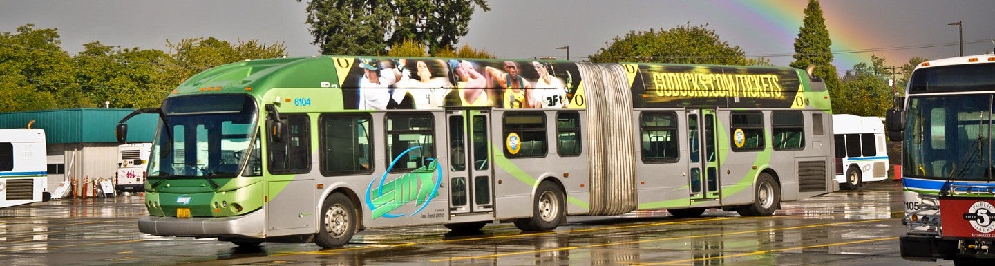 LTD bus parks at depot while rainbow appears in the sky