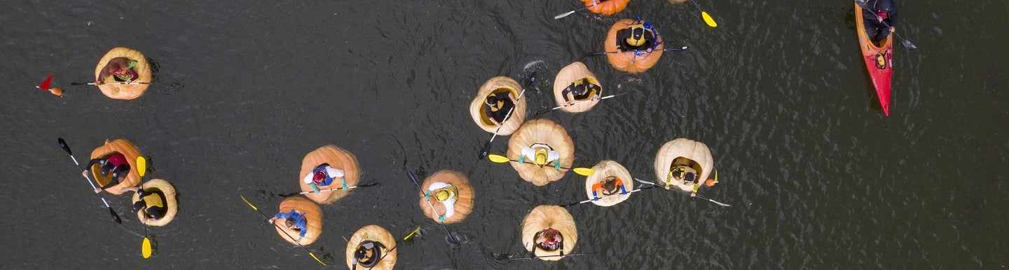Overhead view of Pumpkin Regetta with people paddling the river inside pumpkins