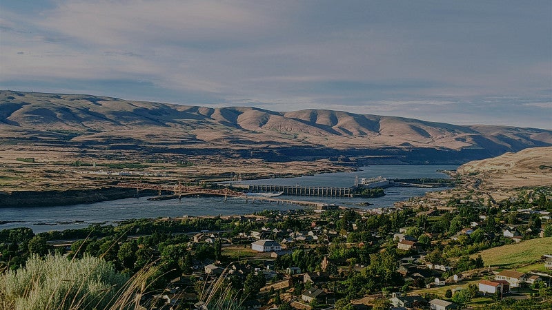 Homes in front of body of water and mountains