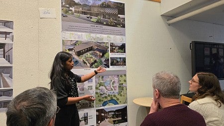 Student presents her work to an audience of architects