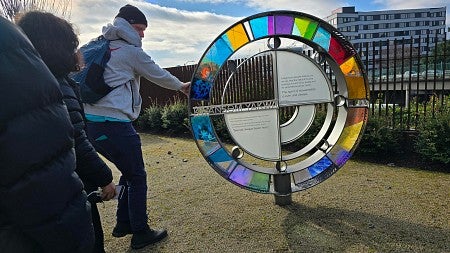 Students spin a colorful stained glass sculpture