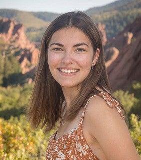 Headshot of Grace Craven smiling with mountains and greenery in the background