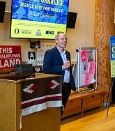 Man holds microphone and speaks at Oakridge Kickoff Event