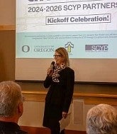 Woman holds microphone and speaks at Tualatin partnership kickoff event